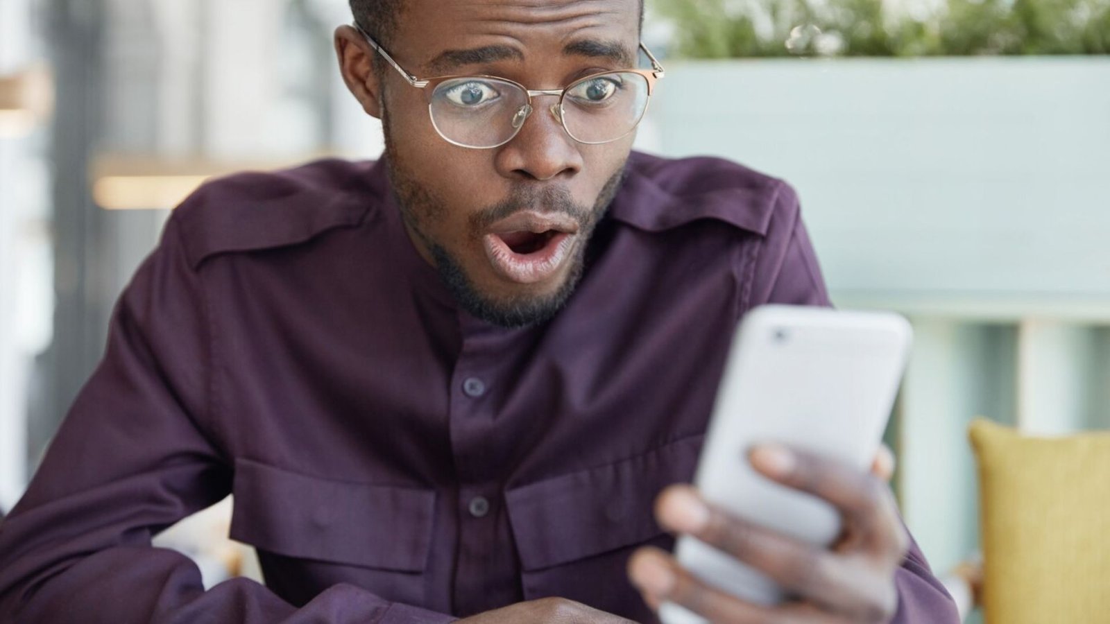 a man holding a smartphone shocked